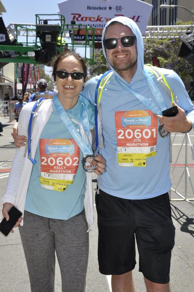 Kelly and her husband standing together after finishing their marathon, smiling and celebrating.